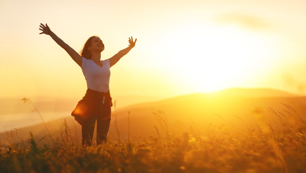 happy woman in golden field spreads arms wide and looks to the sky - God is enough for me