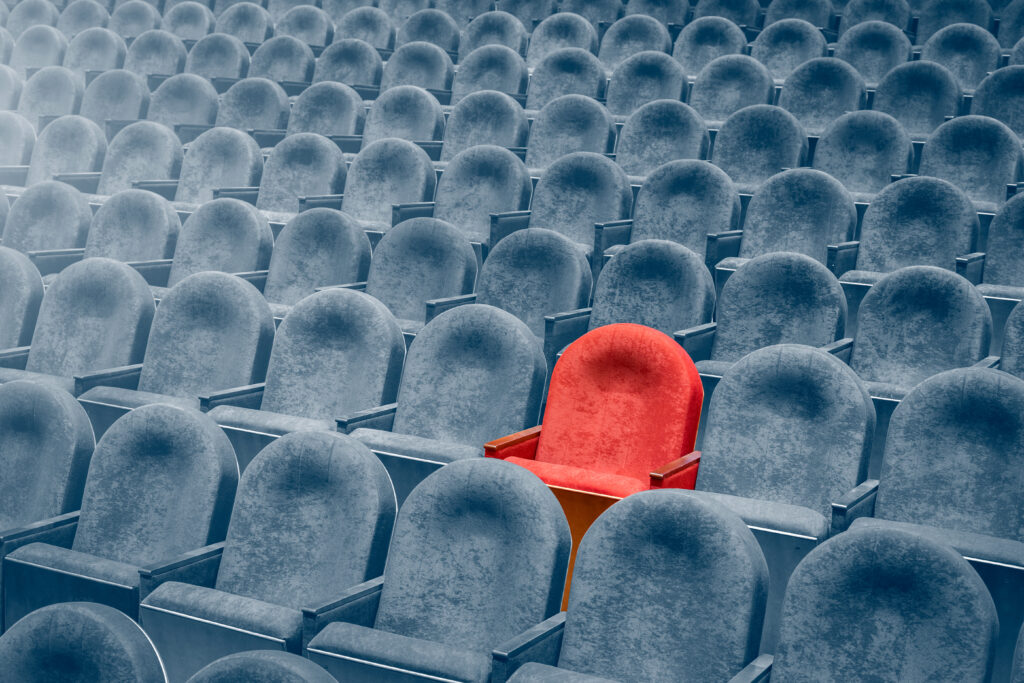 Perform for an Audience of One - Seek God's Favor Only - one red chair among hundreds of blue - Shutterstock