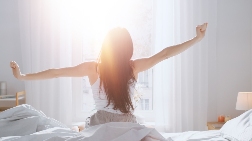You Were Designed for Rest - God Created You to Enjoy Rest - a woman stretches after a good sleep - Shutterstock