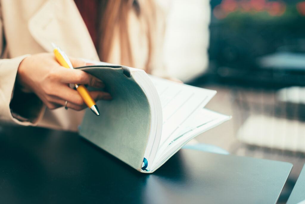 woman examines her schedule with pen in hand - make space in your schedule for God and things of eternal value