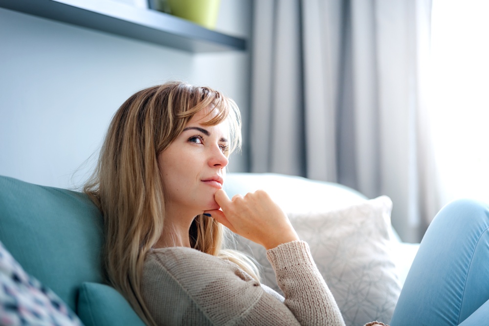 Changing the Way You Think - a woman sitting on the sofa - lost in thought - Shutterstock