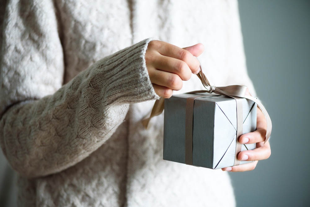Salvation is a Gift that You Must Open - woman's hands opening present - Shutterstock