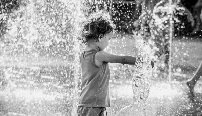 a child playing in water sprinklers