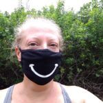 woman wearing a COVID-19 mask with a big smile on it