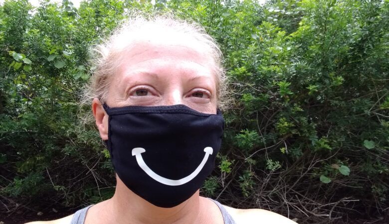 woman wearing a COVID-19 mask with a big smile on it