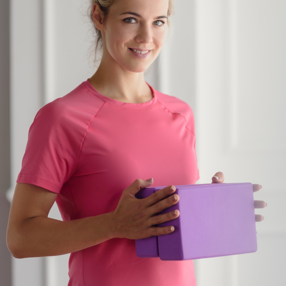 What Do I Need for Yoga Class - Blocks - woman holds two yoga blocks - Shutterstock