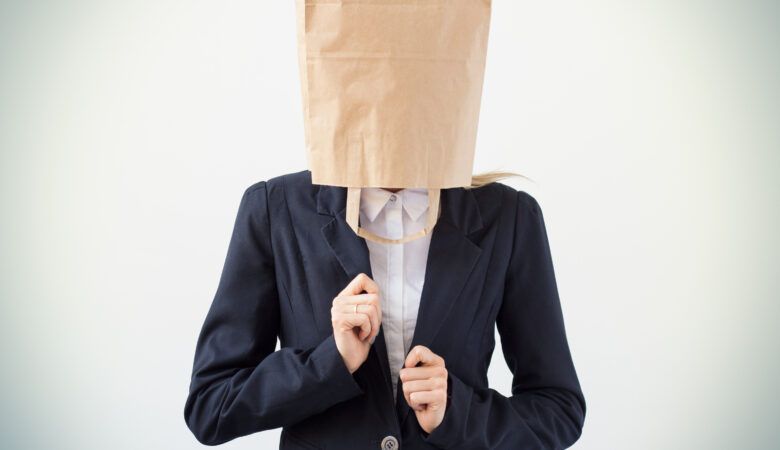a woman in business suit with a paper bag over her head