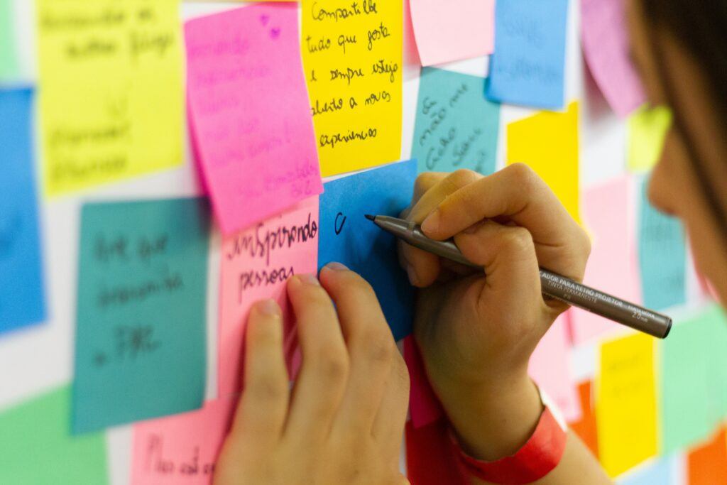 detail of brightly colored sticky notes - pen and female hand writing and planning