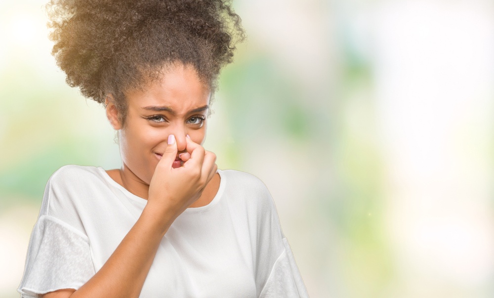Natural Perfumes for Women - no more stinky artificial fragrances for you - young Black woman plugs her nose - Shutterstock