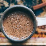 the frothy top view of a hot cup of cocoa