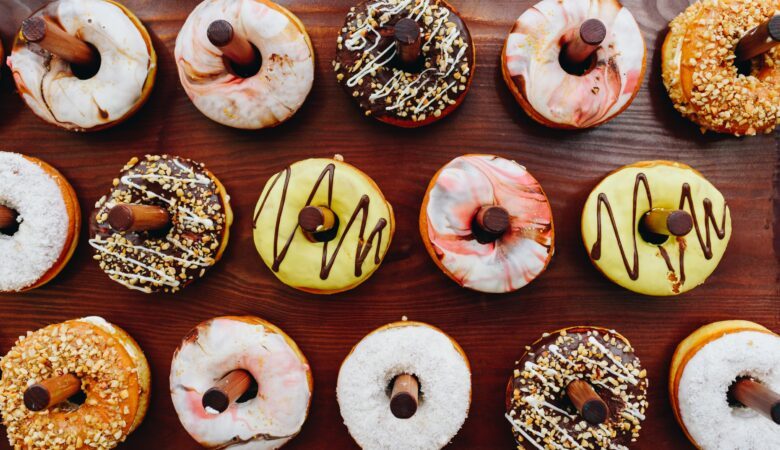 an assortment of doughnuts hanging on wooden pegs