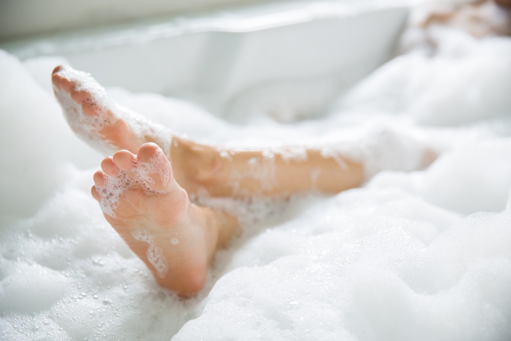 How to Take Time and Make Time - a woman's feet in the bubble bathtub - Shutterstock