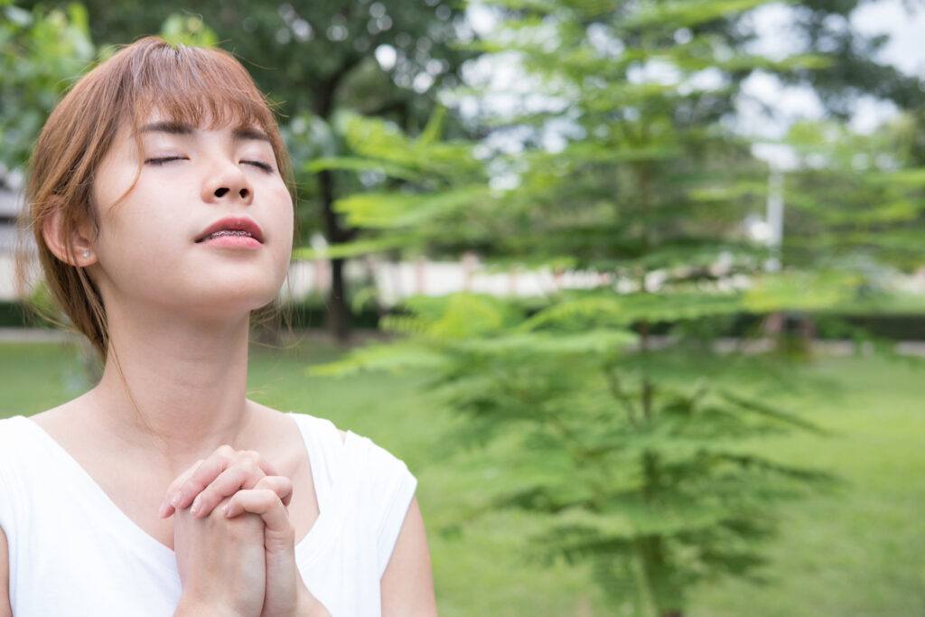 asian woman outside in garden praying -breath prayer