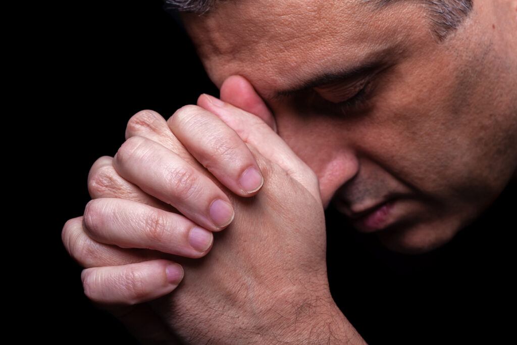 mature man folds hands in prayer - the ancient practice of breath prayer