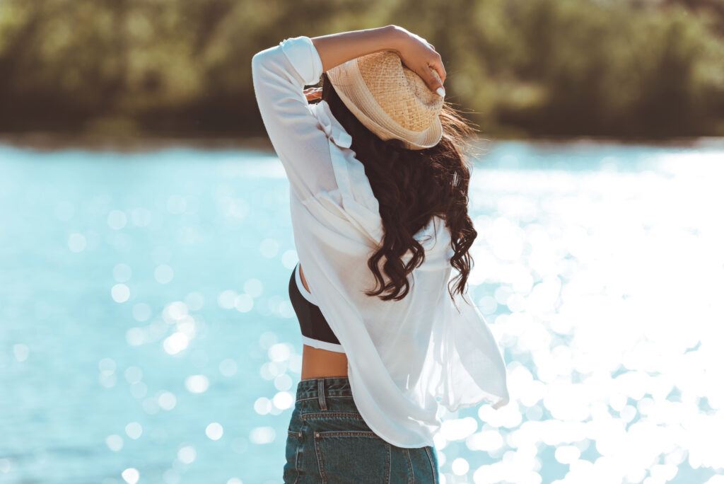 a woman experiences mindfulness at the riverbank - focusing on the movement and color of the water