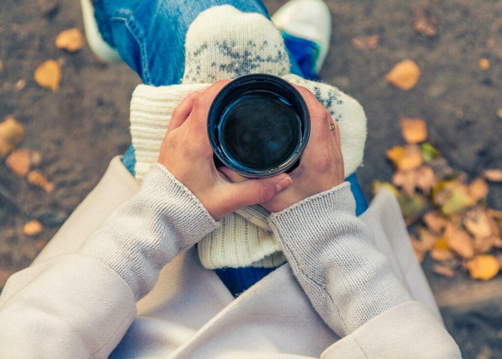 experiencing mindfulness with a cup of coffee - a woman's hands hold the warm mug - photo by Maria Shanina