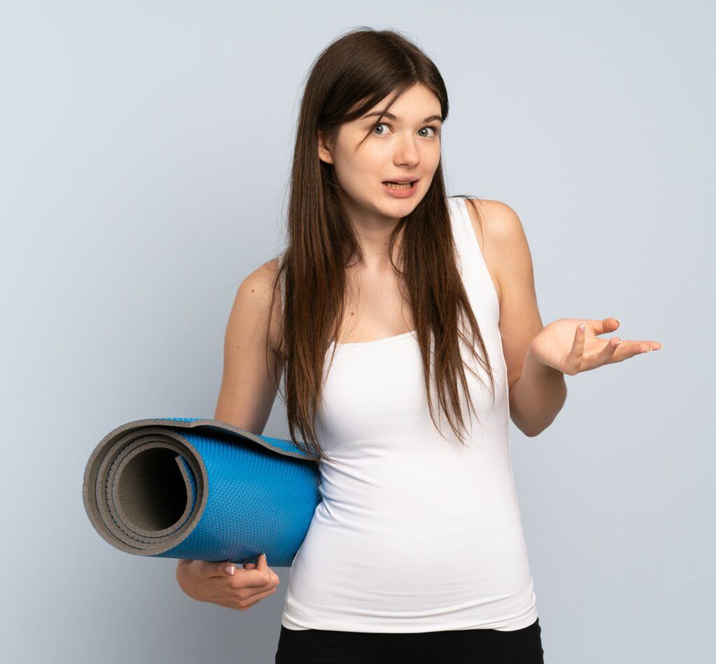 young woman holding yoga mat has questions about yoga - should Christians do yoga