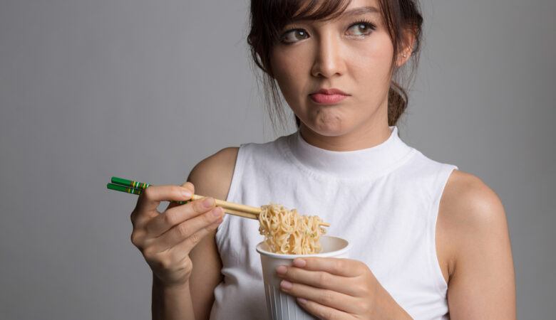 young Asian woman can't taste her noodles