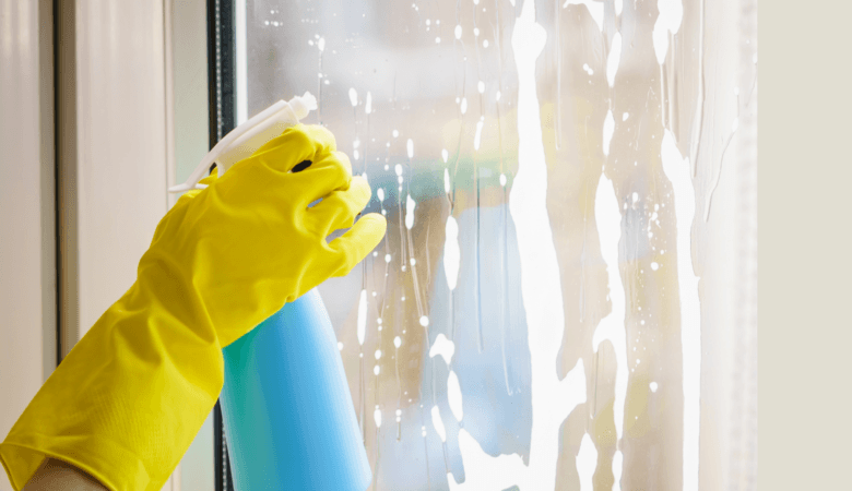 Go Green Cleaning Products and Sprays - yellow gloved hand sprays cleanser on window - Canva
