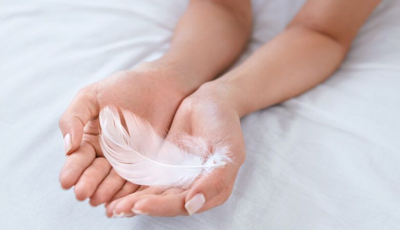 Am I a Highly Sensitive Person? - woman holds feather gently in both hands