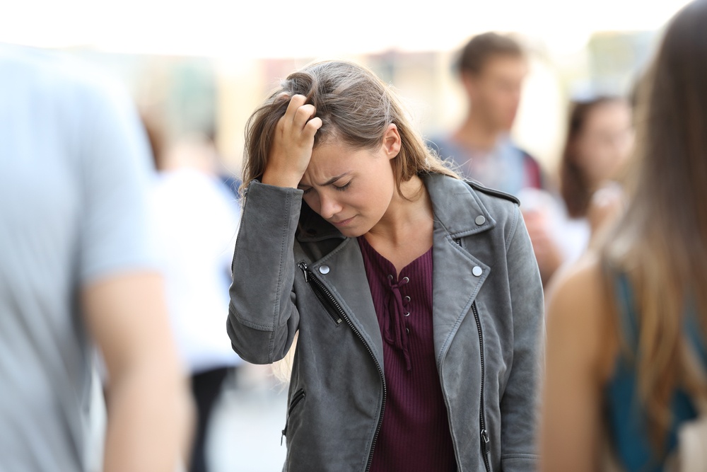 woman overwhelmed in crowd - struggles with heightened sensory stimulation