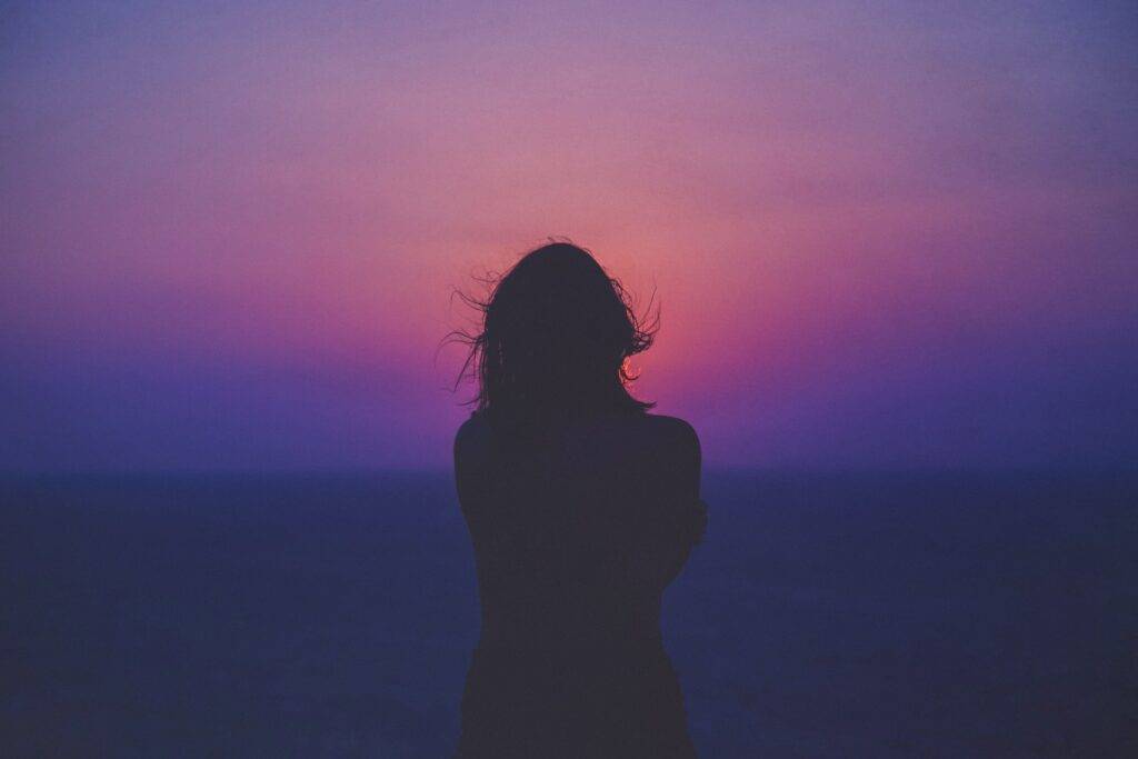 a lonely woman watches the sunrise after a sleepless night - Photo by Sasha Freemind - Unsplash