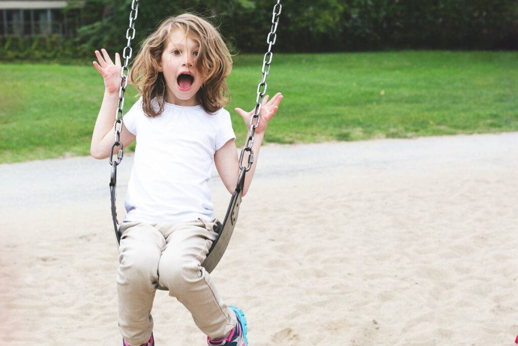 A Child in a Swing Being Goofy - pic from Burst