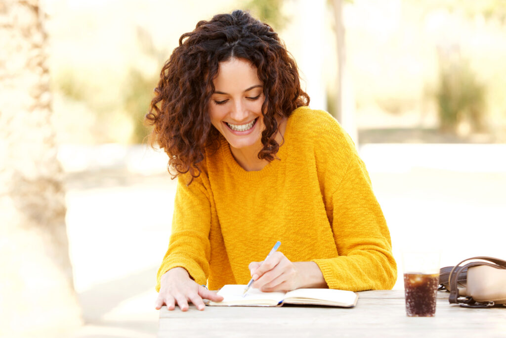 Writing for Fun Young Woman Joyfully Journaling - iStock 915230334